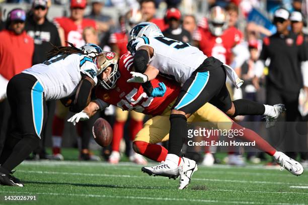 George Kittle of the San Francisco 49ers fumbles the ball as he is tackled by Damien Wilson and Shaq Thompson of the Carolina Panthers during the...