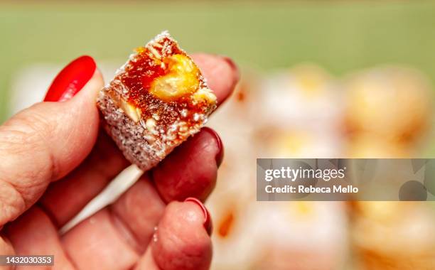 point of view, my hand holding a piece of sweet turkish delight. - turkish delight stock pictures, royalty-free photos & images