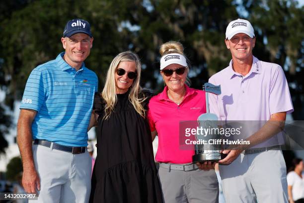 Jim Furyk of the United States, wife Tabitha Furyk, Nicki Stricker and Steve Stricker of the United States celebrate with the trophy after Steve...