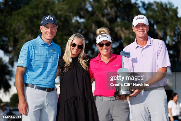 Jim Furyk of the United States, wife Tabitha Furyk, Nicki Stricker and Steve Stricker of the United States celebrate with the trophy after Steve...