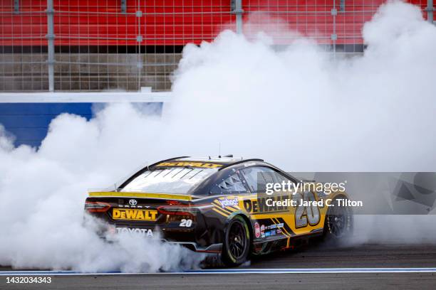 Christopher Bell, driver of the DeWalt Toyota, celebrates with a burnout after winning the NASCAR Cup Series Bank of America Roval 400 at Charlotte...