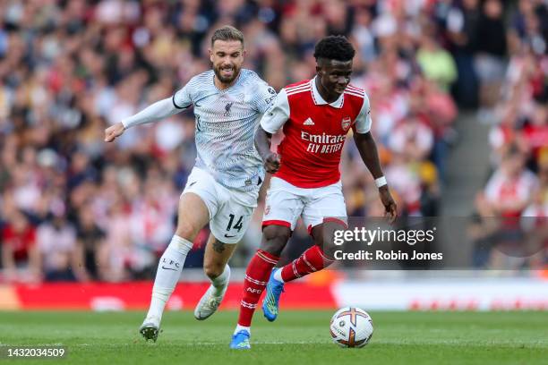 Jordan Henderson of Liverpool gives chase to Bukayo Saka of Arsenal during the Premier League match between Arsenal FC and Liverpool FC at Emirates...