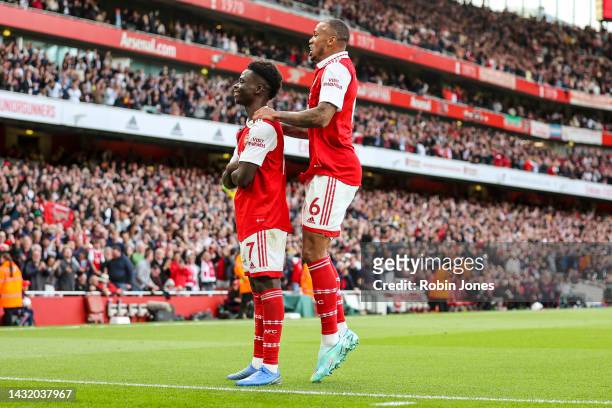 Bukayo Saka of Arsenal celebrates after scoring a goal to make it 2-1 with team-mate Gabriel during the Premier League match between Arsenal FC and...