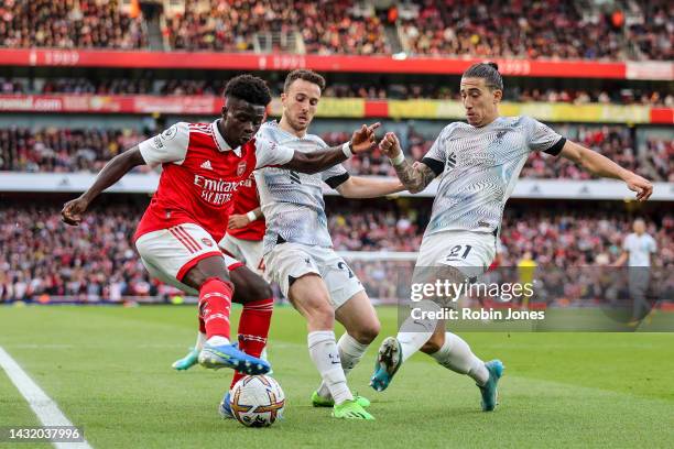 Dioga Jota and Kostas Tsimikas of Liverpool close down Bukayo Saka of Arsenal during the Premier League match at Emirates Stadium on October 09, 2022...