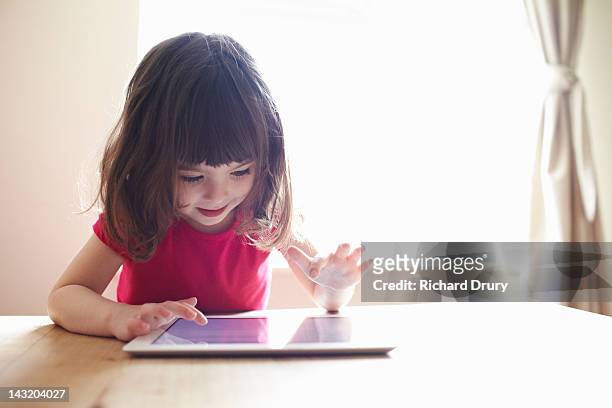 4 year old girl using digital tablet on table - 4 5 ans photos et images de collection