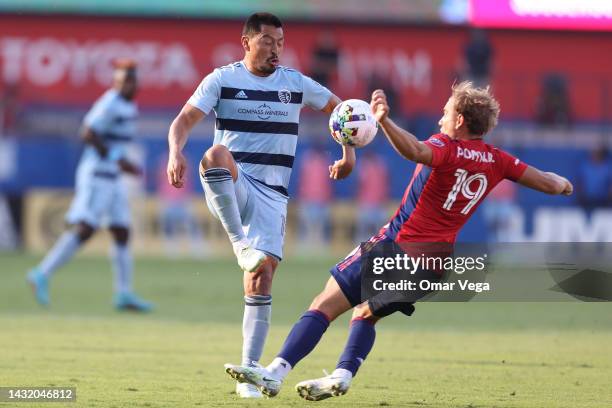 Roger Espinoza of Sporting Kansas City is challenged by Paxton Pomykal of FC Dallas during the game at Toyota Stadium on October 9, 2022 in Frisco,...