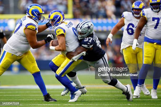 Matthew Stafford of the Los Angeles Rams is sacked by Osa Odighizuwa of the Dallas Cowboys during the fourth quarter at SoFi Stadium on October 09,...