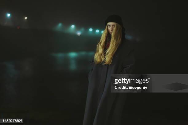 blonde woman in coat on night street. foggy weather. city lights. autumn - the light of the moon film stock pictures, royalty-free photos & images