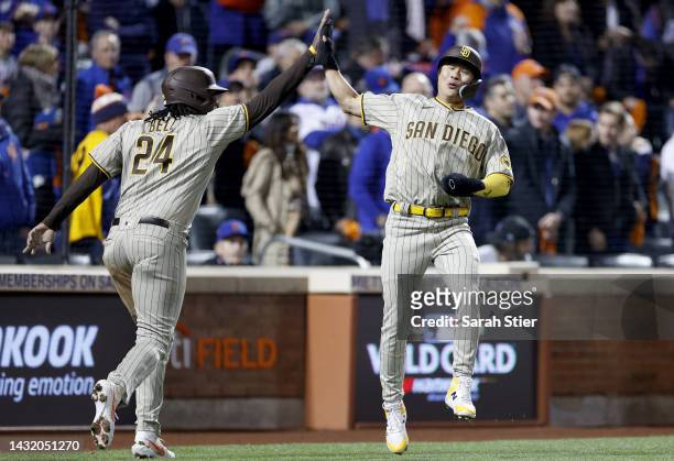 Josh Bell and Ha-Seong Kim of the San Diego Padres celebrate after scoring on a two RBI single hit by Austin Nola against the New York Mets during...