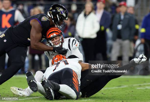 Joe Burrow of the Cincinnati Bengals is sacked by Jason Pierre-Paul and Calais Campbell of the Baltimore Ravens during the first quarter at M&T Bank...