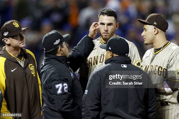 Umpire Alfonso Marquez checks the ear of Joe Musgrove of the San Diego Padres during the sixth inning against the New York Mets in game three of the...