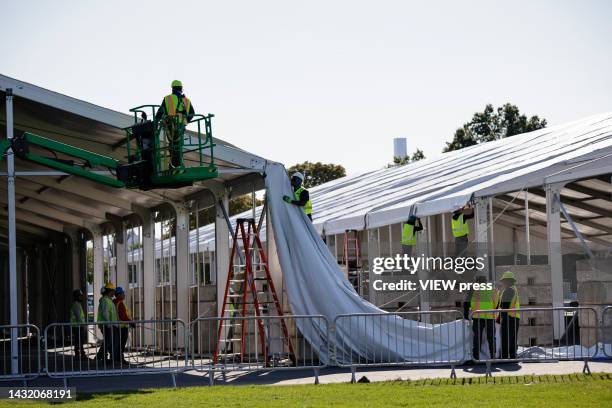 Workers assemble emergency tents to house asylum seekers on Randall's Island on October 9, 2022 in New York City. NYC Mayor Eric Adams declared a...