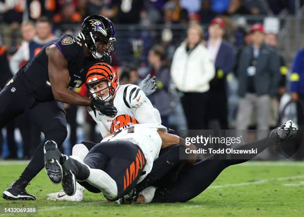 Joe Burrow of the Cincinnati Bengals is sacked by Jason Pierre-Paul and Calais Campbell of the Baltimore Ravens during the first quarter at M&T Bank...