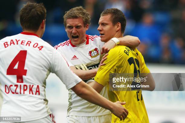 Goalkeeper Bernd Leno, Andre Schuerrle and Bastian Oczipka of Leverkusen celebrate after Leno saved a penalty of Sejad Salihovic of Hoffenheim during...