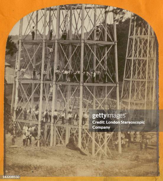 Stereoscopic image of construction workers crowding the piers of the Crumlin Viaduct during its construction over the village of Crumlin in South...