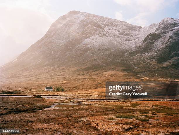 farmhouse at the foot of mountain range - highlands escocesas fotografías e imágenes de stock