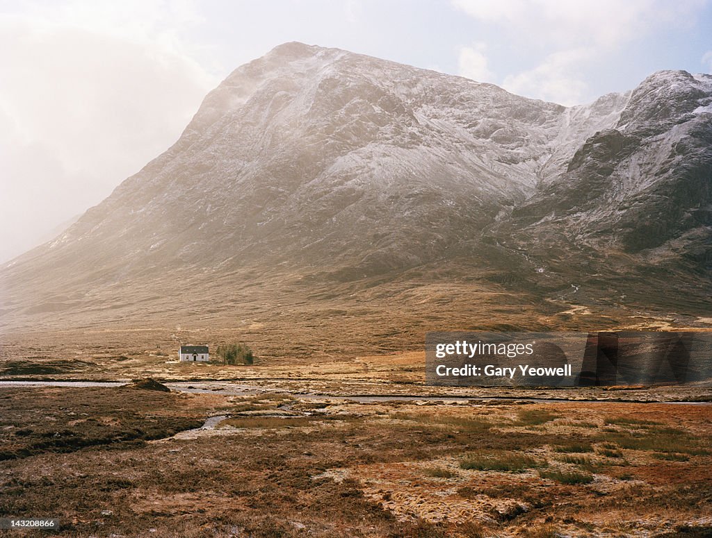 Farmhouse at the foot of mountain range