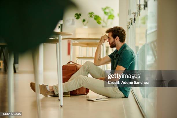 anxiety, stress and student at university with anxiety for test. young man with headache, worried and frustrated sitting on the floor. burnout in education, learning and stressed with exam or result - defeat 個照片及圖片檔