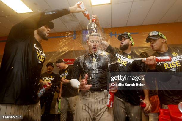 Manny Machado of the San Diego Padres celebrates with his teammates in the locker room after defeating the New York Mets in game three to win the...