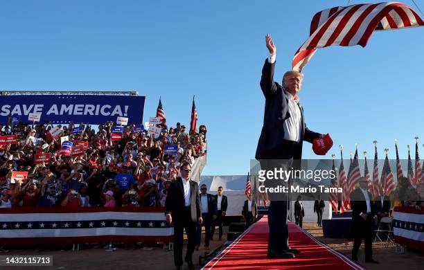 Former U.S. President Donald Trump tosses Save America hats to the crowd at a campaign rally at Legacy Sports USA on October 09, 2022 in Mesa,...