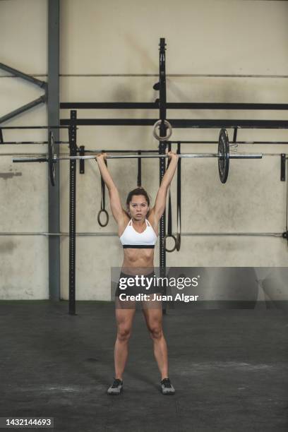 sporty lady lifting weight in gym - lange halter stockfoto's en -beelden