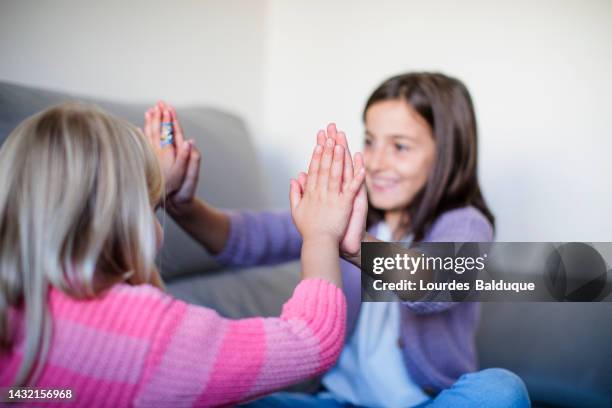 girls playing clapping on the couch - clapping game stock pictures, royalty-free photos & images