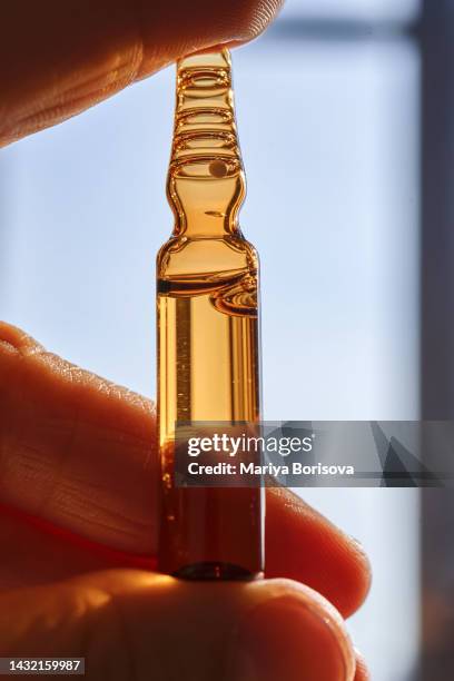 one glass ampoule in a woman's hand. - vitamin a stock pictures, royalty-free photos & images