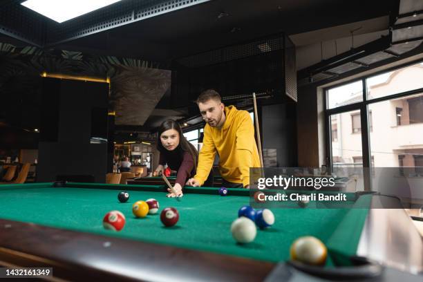 young caucasian couple playing pool table together - snooker and pool stock pictures, royalty-free photos & images