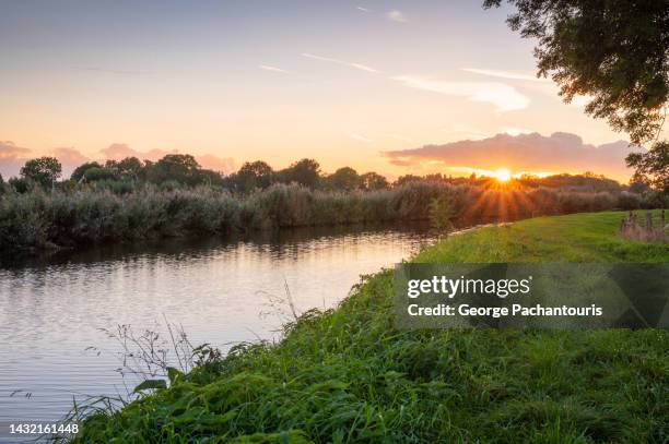 sunset over the river and grass - netherlands sunset stock pictures, royalty-free photos & images