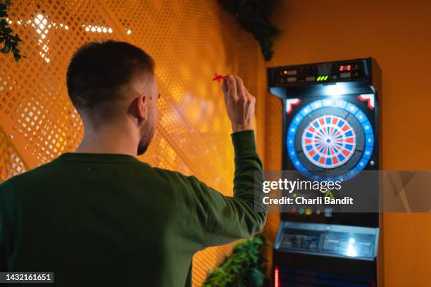 young man playing darts - dartboard stock pictures, royalty-free photos & images