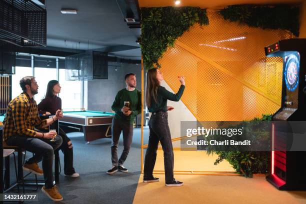 caucasian male and female friends playing darts - man darts stock pictures, royalty-free photos & images