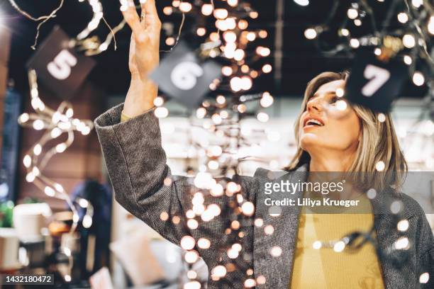 beautiful woman in the store chooses new year decorations. - portrait choice stockfoto's en -beelden