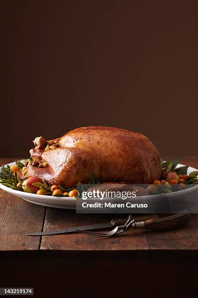 turkey dish on wood surface with carving utensils - thanksgiving indulgence stock pictures, royalty-free photos & images