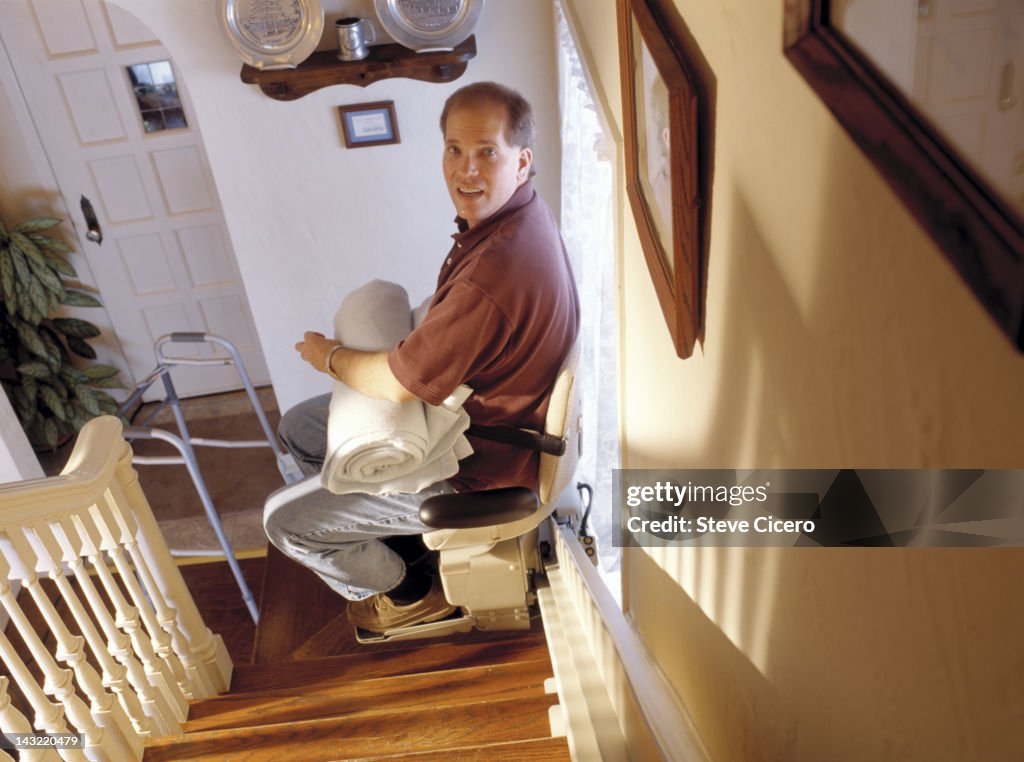 Man in stair lift doing chores