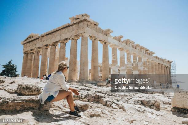 mujer relajándose mientras mira el templo del partenón contra el cielo despejado - grecia europa del sur fotografías e imágenes de stock