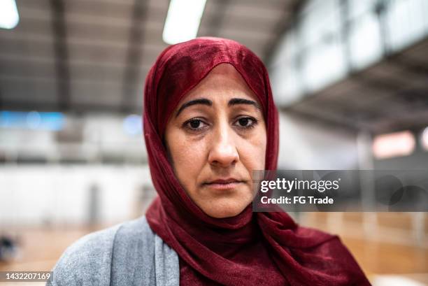 porträt einer reifen frau mit hijab in einem gemeindezentrum - religious service stock-fotos und bilder