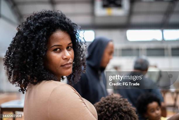 portrait of a young woman waiting in line at a community center - refugees stockfoto's en -beelden