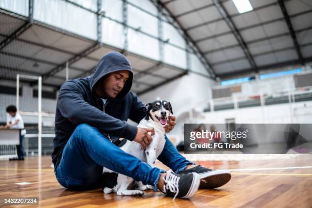young man with his dog at a community center - homeless shelter man stock pictures, royalty-free photos & images