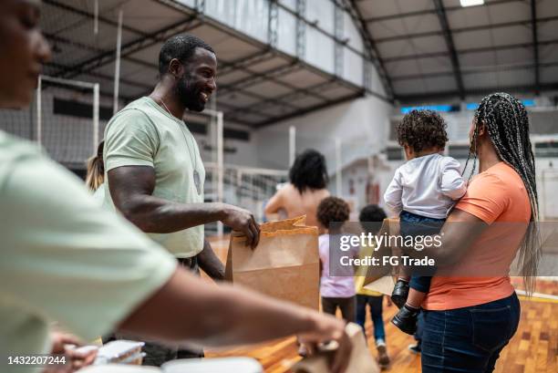 soldier giving food to a mother and her son at a community center - 1 year poor african boy stock pictures, royalty-free photos & images