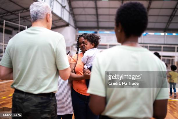 soldiers registering mother with children at a community center - 1 year poor african boy stock pictures, royalty-free photos & images