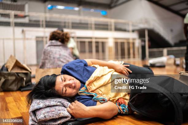 flüchtlingsfrau schläft in einer unterkunft - flüchtlingsunterkunft stock-fotos und bilder