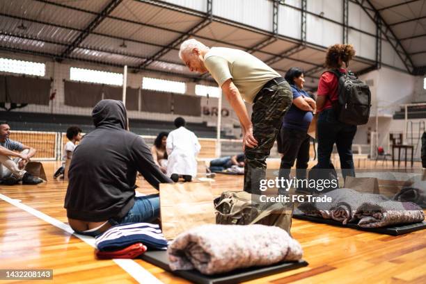 soldier talking to a refugee man at a community center - helping refugee stock pictures, royalty-free photos & images