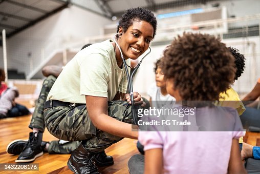 Army doctor examining refugee children at a community center