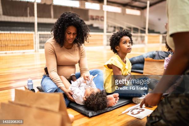 family of refugee in a sheltering at a community center - 1 year poor african boy stock pictures, royalty-free photos & images