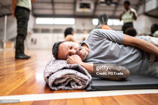 refugee man sleeping in a sheltering - community center stock pictures, royalty-free photos & images