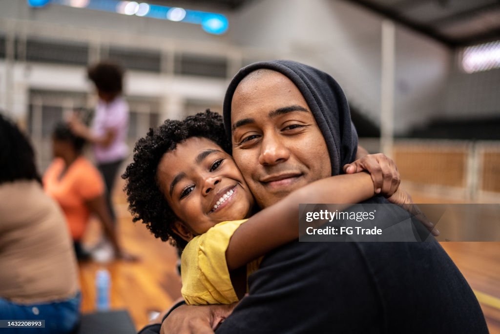 Retrato de padre e hija abrazándose en un centro comunitario
