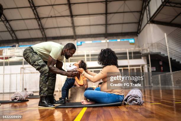 soldier talking to a mother and her son at a community center - 1 year poor african boy stock pictures, royalty-free photos & images