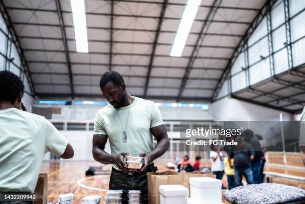 soldiers organizing donations at a gymnasium - homeless shelter man stock pictures, royalty-free photos & images