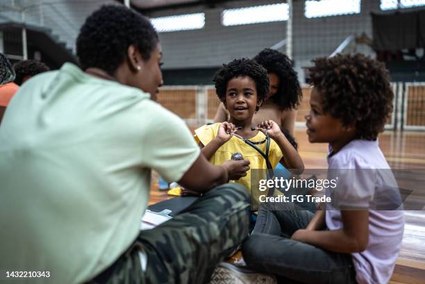 army doctor playing with refugee children - kids at community center stock pictures, royalty-free photos & images