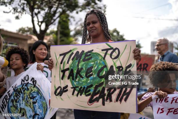 une femme mûre manifestant dans la rue - climate change protest photos et images de collection